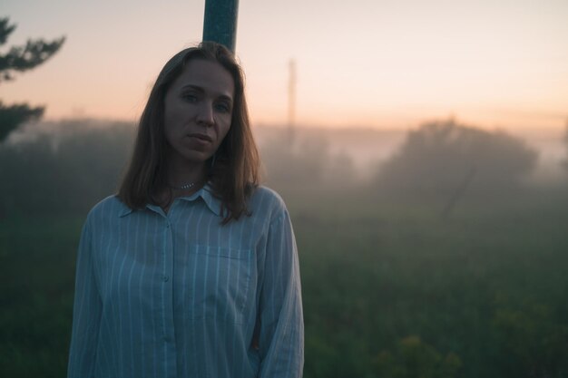 Foto frau auf einem feld mit nebligem nebel