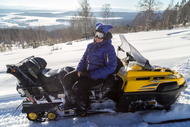 Frau auf einem Schneemobil.