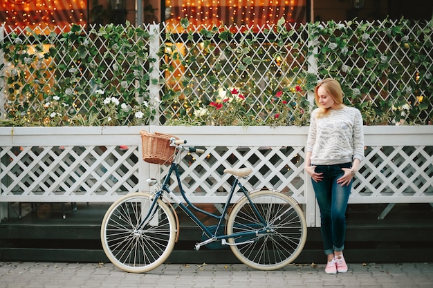 Frau auf einem Weinlesefahrrad an der Straße