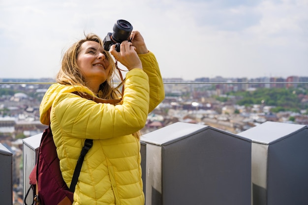 Frau auf einer Reise fotografiert die Stadt aus großer Höhe. Frau mit einer Kamera. Fotografinnen