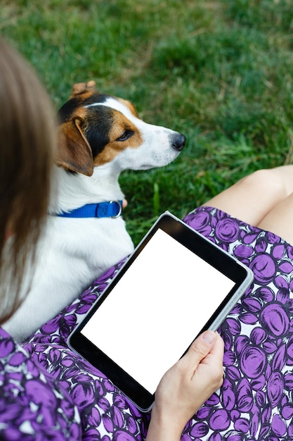 Frau auf Gras mit Tablette