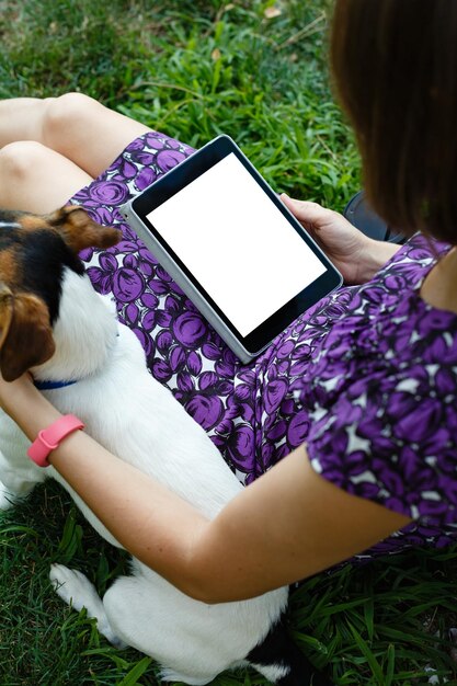 Frau auf Gras mit Tablette