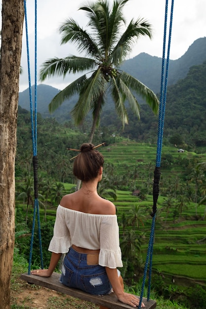 Frau auf Seilschaukeln mit schöner Aussicht auf Reisterrassen in Bali