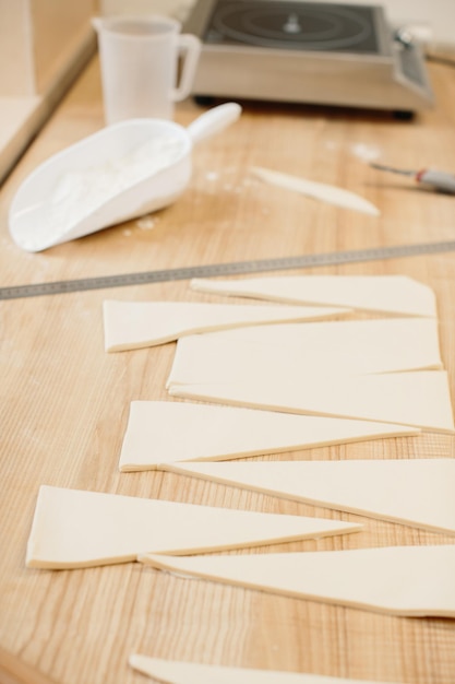 Frau Bäcker schneidet den Teig in Dreiecke für Croissants Herstellung von Croissants in der Bäckerei