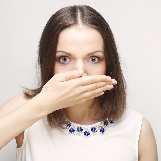 Frau bedeckt das Gesicht mit ihrer Hand