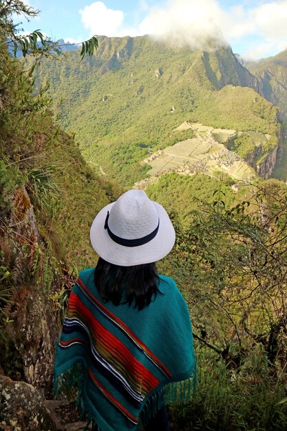 Frau beeindruckt von der Aussicht auf die Ruinen der Inka-Zitadelle von Machu Picchu vom Berg Huayna Picchu Peru