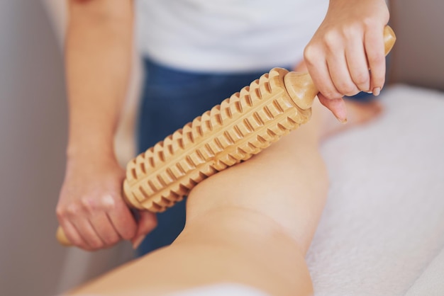 Foto frau bei massagetherapie mit holzwerkzeugen