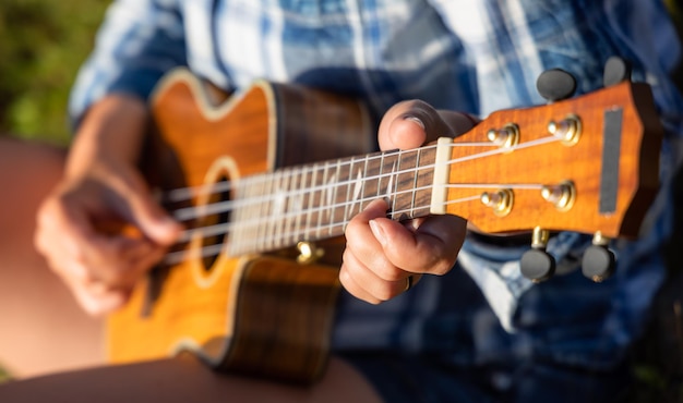 Frau bei Sonnenuntergang, die Ukulele spielt