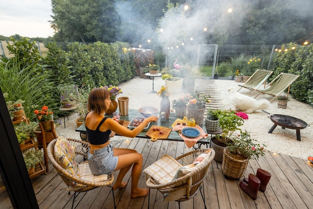 Frau beim Abendessen auf der Terrasse im Hinterhof