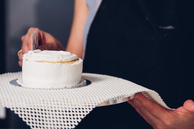 Frau beim Dekorieren von Kuchen mit Sahne