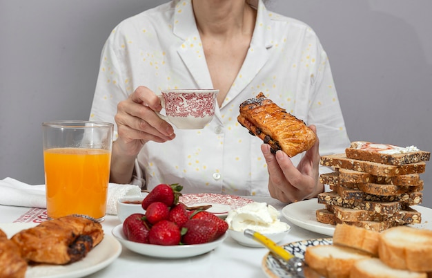 Frau beim Frühstück im Pyjama