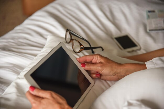 Frau benutzt ein digitales Tablet im Bett