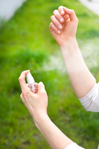 Frau benutzt Insekten- und Mückenspray.