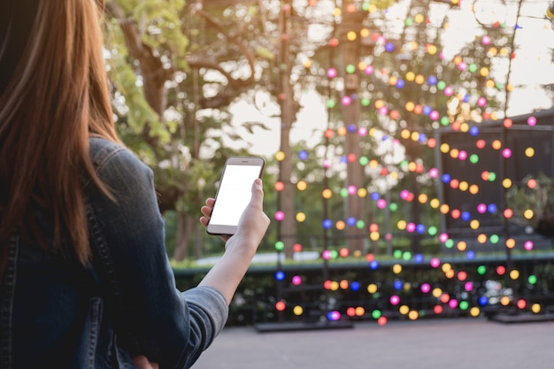 Foto frau benutzte intelligentes telefon auf dem park, verspotten oben auf schirm