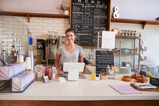 Frau bereit, hinter der Theke in einem Café zu dienen