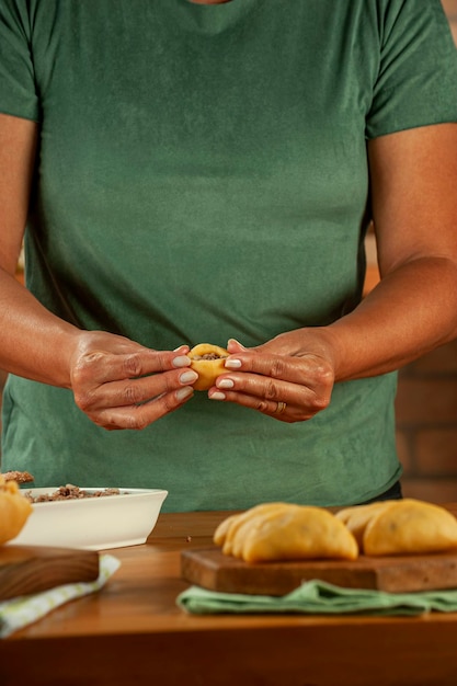 Frau bereitet brasilianische Snacks zu, die Kroketten mit Risolis de Carne füllen