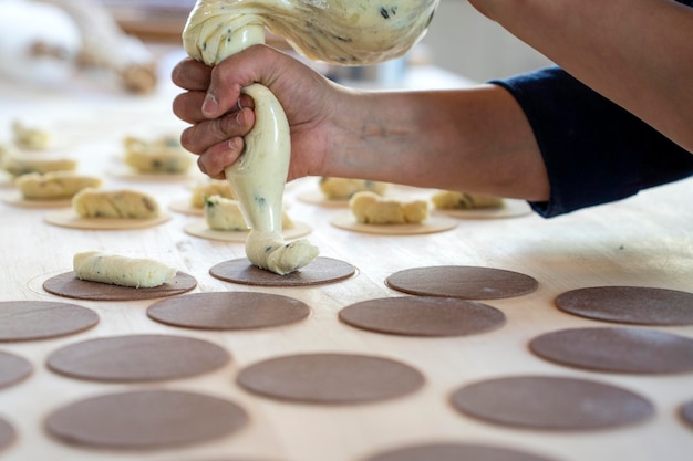 Frau bereitet frisch zubereitete Ravioli in der Nudelfabrik zu Verwenden Sie einen Spritzbeutel oder sac a poche, um gefüllte Nudeln Ravioli culurgiones agnolotti zu machen Konzentrieren Sie sich auf gefüllt