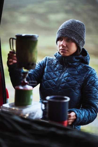 Frau bereitet heißes Wasser für ihren Morgenkaffee vor