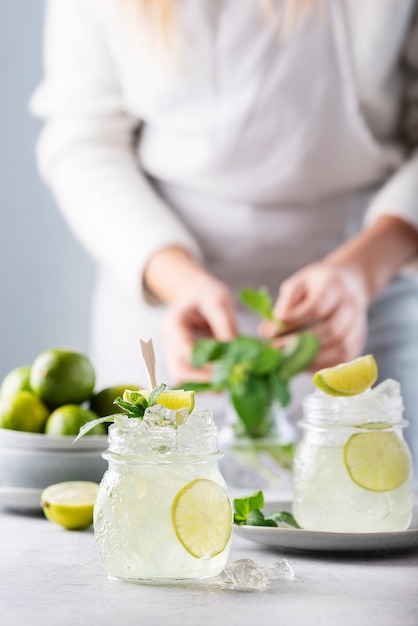 Frau bereitet Mojito-Cocktail vor