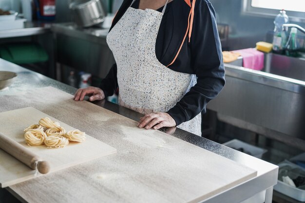 Frau bereitet traditionelle Pasta in der italienischen Fabrik zu