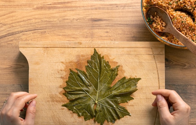 Frau bereitet türkisches Sarma in der Küche zu