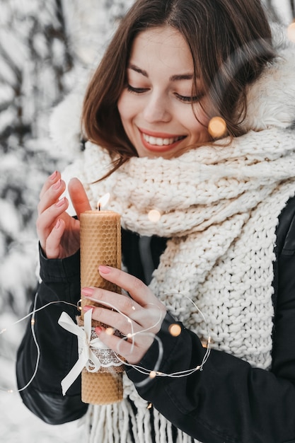 Frau betrachtet Kerzenlicht im Winter.