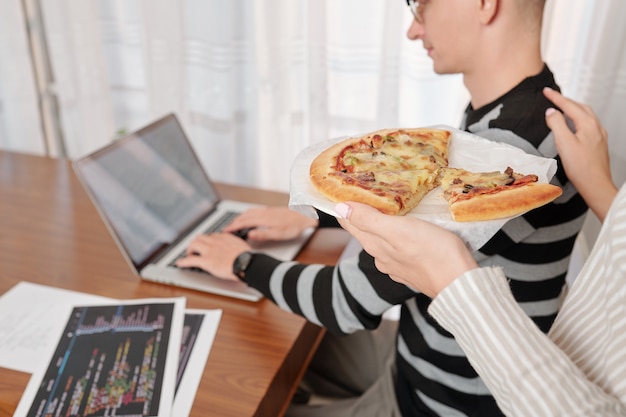 Frau bringt Pizza zum Arbeiter