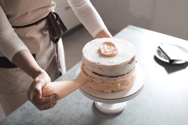 Frau dekoriert leckeren Kuchen mit Schlagsahne auf Tablett