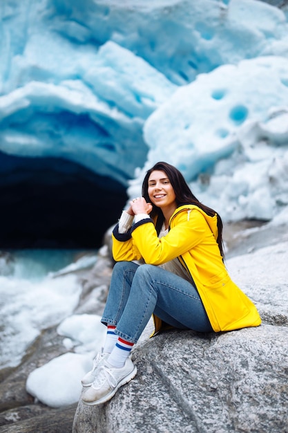 Frau, die am Gletscher wandert, genießt Freiheit Touristin in gelber Jacke in der Nähe eines großen Gletschers