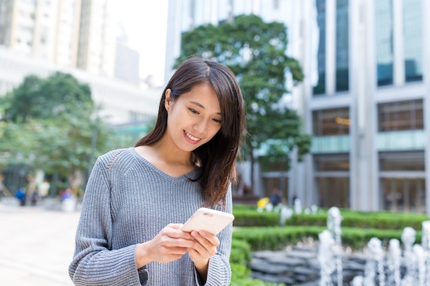 Frau, die am Handy in Hong Kong City arbeitet