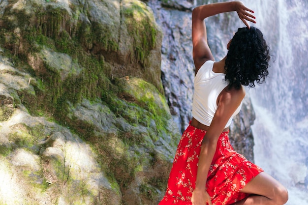 Frau, Die Am Hintergrund Des Wasserfalls Steht. Urlaubs- und Tourismuskonzept