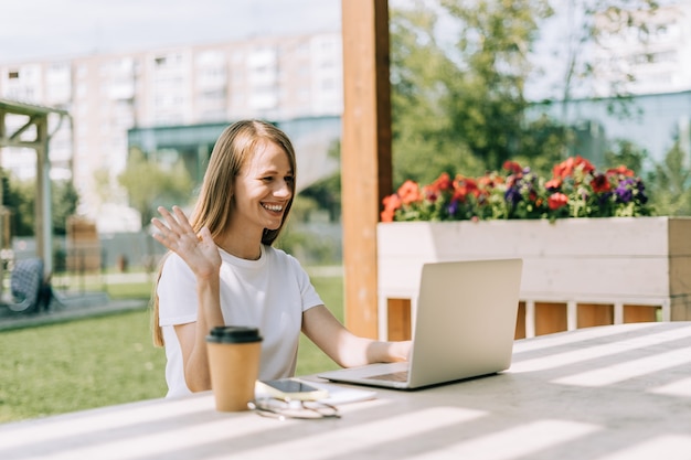 Frau, die am Laptop draußen arbeitet