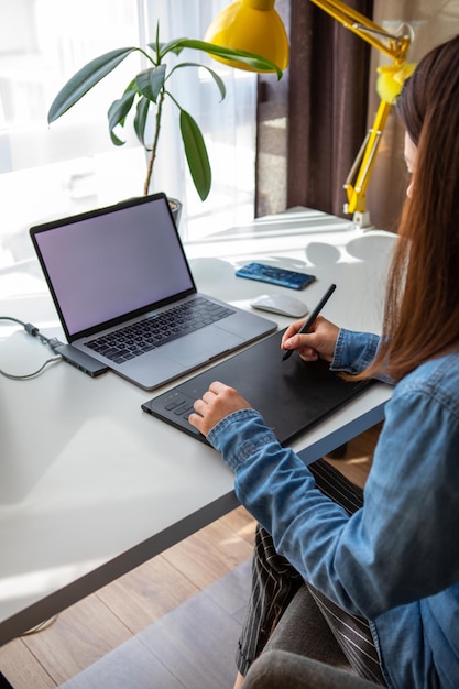 Frau, die am Laptop zu Hause arbeitet