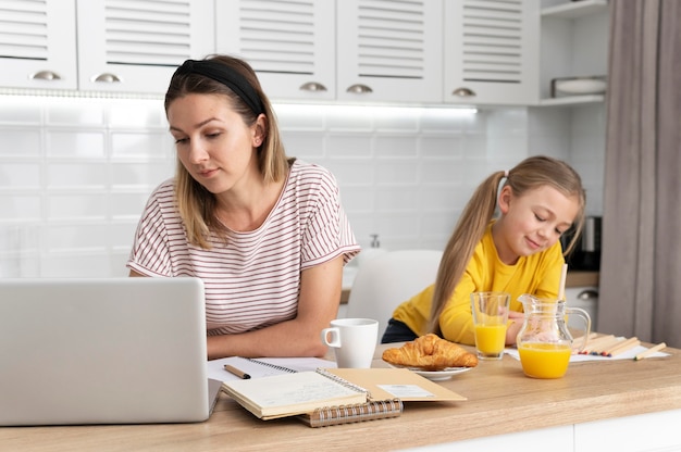 Frau, die am schreibtisch mit mädchen arbeitet