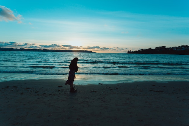 Frau, die am Strand spazieren geht, traurige Töne, Selbsthilfe und minimales Konzept, Blautöne