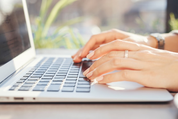 Frau, die an einem Computer in einem Café arbeitet