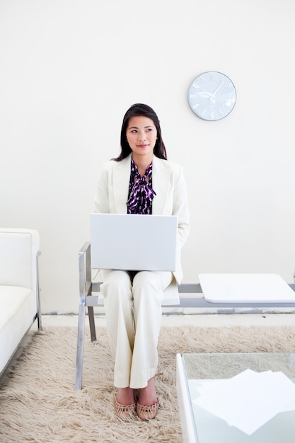 Frau, die an einem Laptop in einem wiating Raum arbeitet