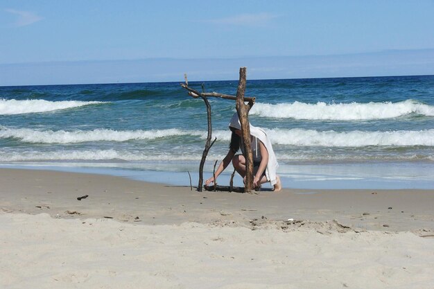 Foto frau, die an einem sonnigen tag am strand mit stöcken spielt