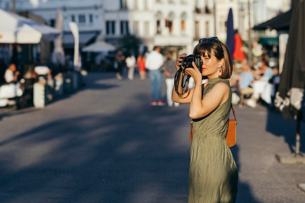 Frau, die an einem sonnigen Tag in einer Stadt fotografiert