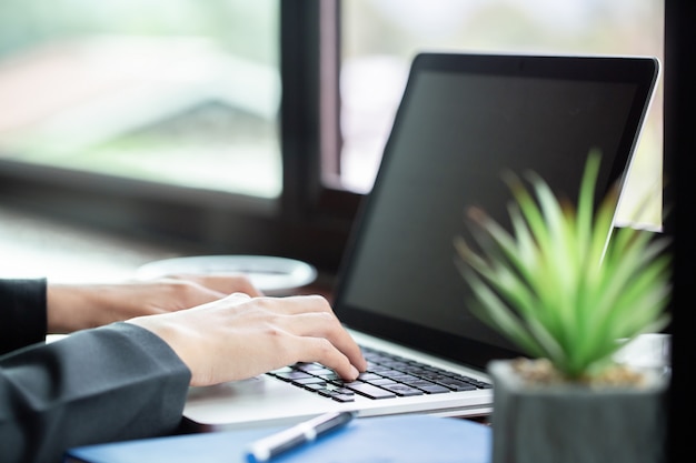 Frau, die an ihrem Laptop auf einer Terrasse arbeitet