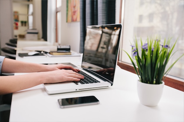 Frau, die an Laptop bei der Arbeit arbeitet