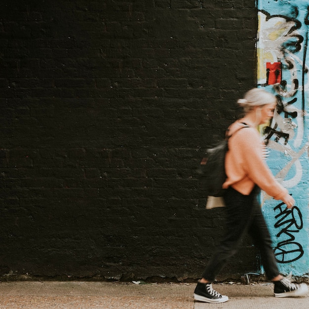 Frau, die an Street-Art-Wandbild vorbeigeht