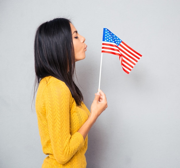 Frau, die auf amerikanische Flagge bläst