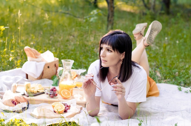 Frau, die auf dem Gras im Park liegt und den Tag genießt. Das Konzept von Freizeit, Urlaub