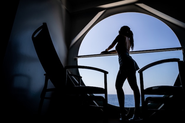 Frau, die auf dem Kreuzschiff genießt Meerblick vom Balkon sich entspannt