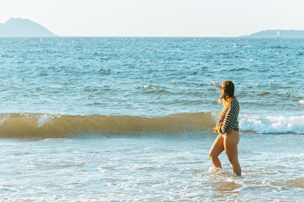 Frau, die auf dem Strand geht