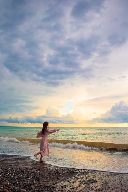 Frau, die auf dem Strand liegt, der Sommerferien betrachtet, die das Meer betrachten