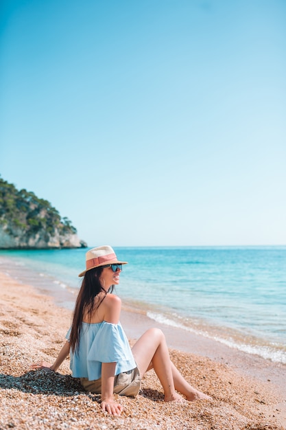 Frau, die auf dem Strand liegt, der Sommerferien genießt