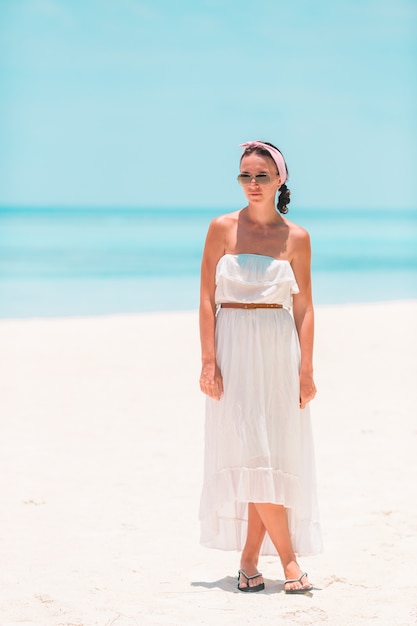 Frau, die auf den Strand genießt Sommerferien das Meer betrachtend legt