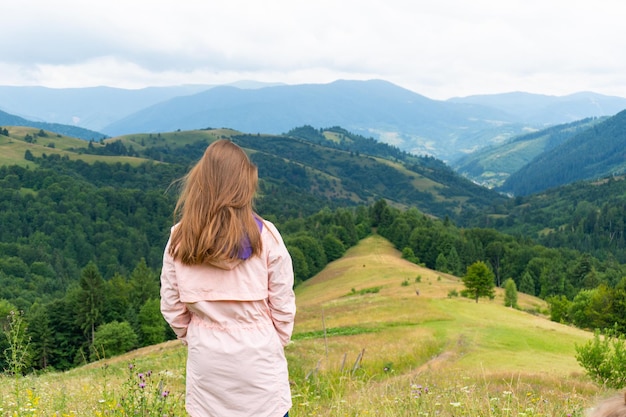 Frau, die auf einem Hügel steht und Berge mit Wäldern betrachtet Natura-Panoramablick im Freien